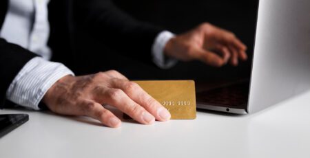 hand using card buy online with laptop